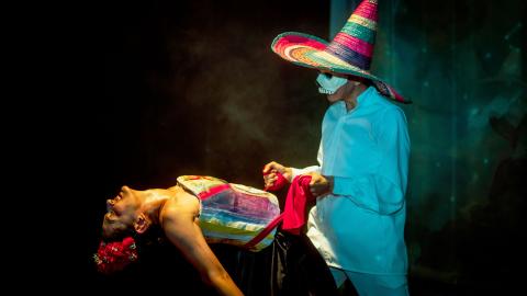 Frida siendo sostenida por un hombre con máscara